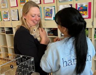 Un miembro del equipo de Hannah ayudando a una maestra a cuidar una pequeña Mascota del salón de clases