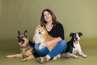 Una Tutora de acogida sentada con sus tres perros rescatados